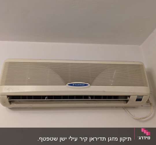 מזגן קיר מותקן עם פתחי אוורור וכבל חשמל